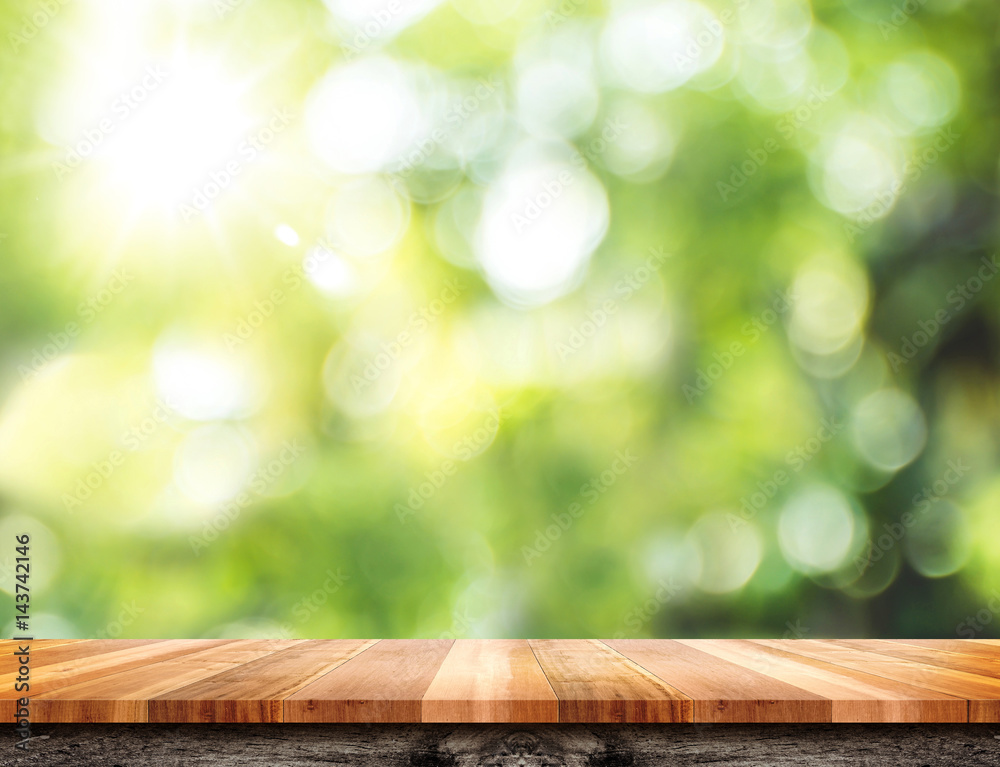 Empty brown wood table top with green blur nature sun light,Mock up for display or montage of product Empty brown wood table top with green blur nature sun light,Mock up for display or montage of product