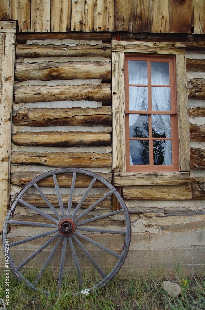 Old west cabin window and wagon wheel