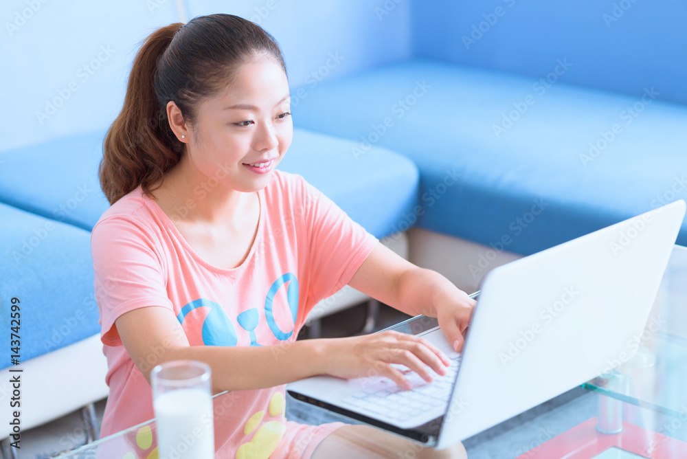 Asian Chinese young woman using laptop in home. Asian Chinese young woman using laptop in home.