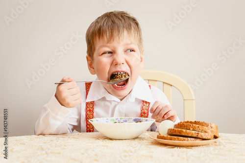 boy in the shirt eating lentils