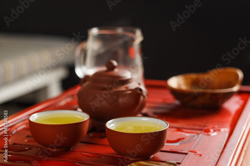 Two bowls with fresh oolong tea on tea desk.