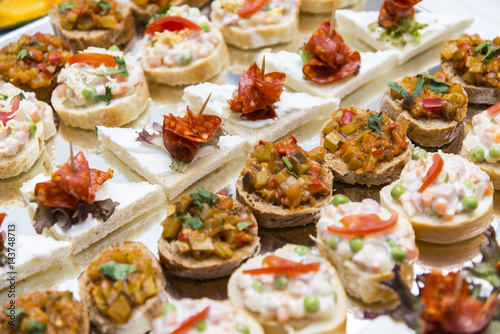 Colorful canape with vegetables and sausage on a slate plate