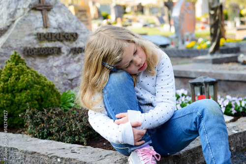 sad girl in front of grave photo