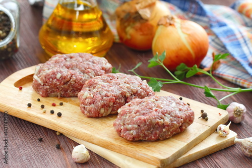 Raw cutlets on a chopping board and ingredients