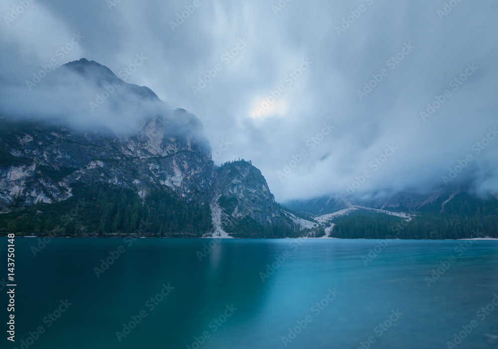 Cloudy and foggy morning on the alpine lake Lago di Braies, dolomites, italy