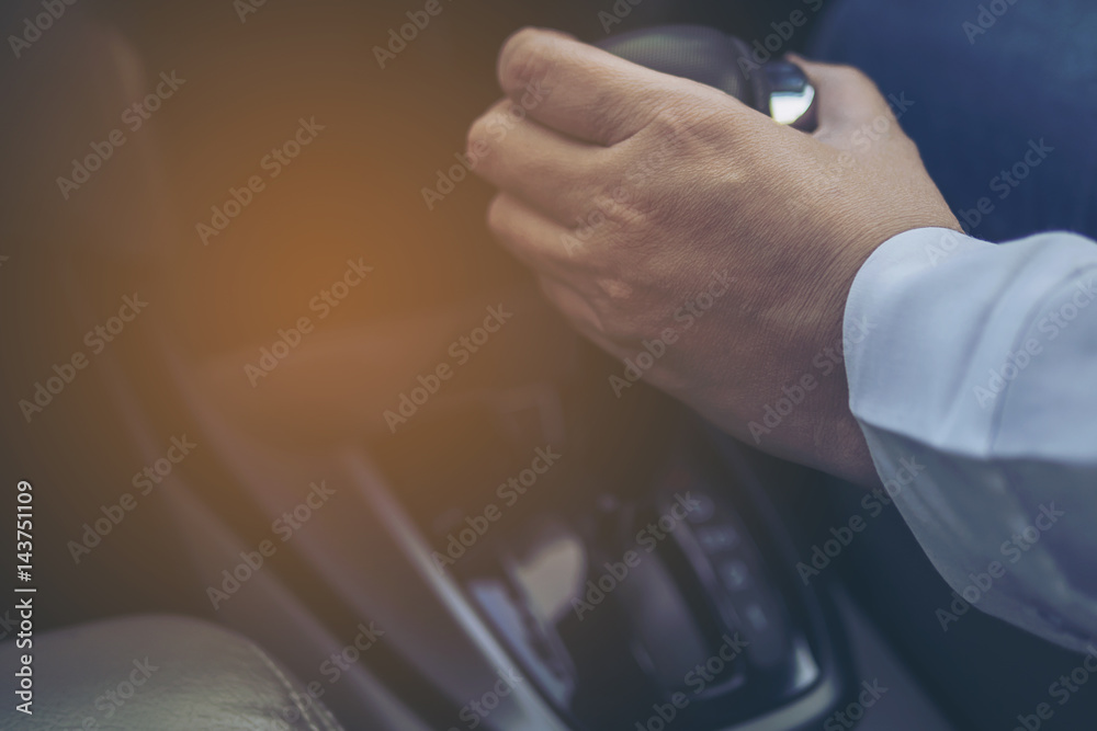 Man driving car while holding automatic gear shift control