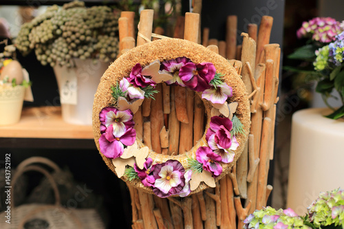 Stroik, dekoracja ze sztucznych kwiatów na krążku z trzciny.