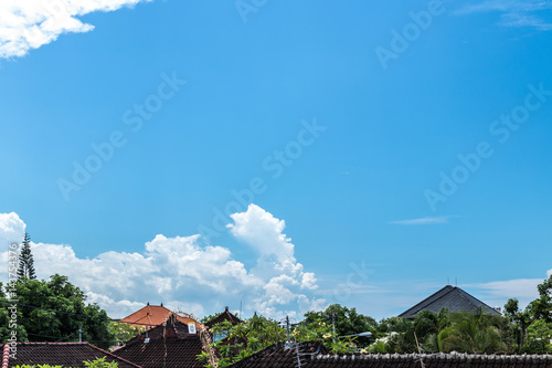 Blue sky with clouds, balinese landscape, tropical Bali island, Indonesia. Balinese houses.