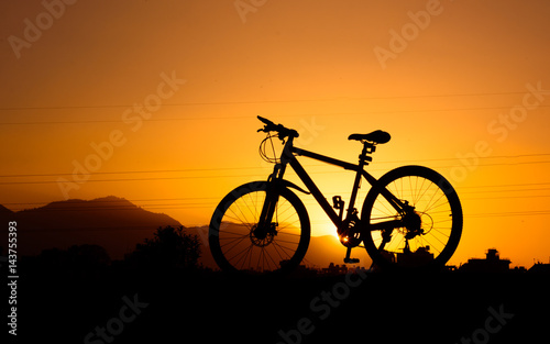 Fototapeta Naklejka Na Ścianę i Meble -  silhouette of parked bicycle on warm tone with some copy space