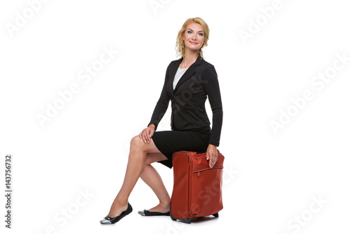 business woman sitting on travel case photo