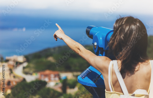 Hipster tourist look observant binoculars telescope on panoramic view, traveler with backpack on background mountain and blue sea landscape horizon, young girl hiker pointing hands