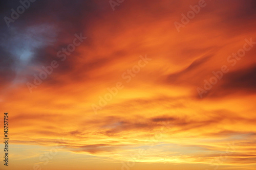 Orange sunset on the cloudy sky photo