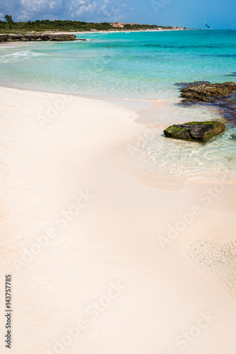 Obraz na płótnie Wild tropical sandy beach with clear turquoise waters, soft waves, rocks and beautiful sky. Caribbean sea scenery in Playa Del Carmen, Riviera Maya, Mexico. Natural summer background with copy space. w salonie