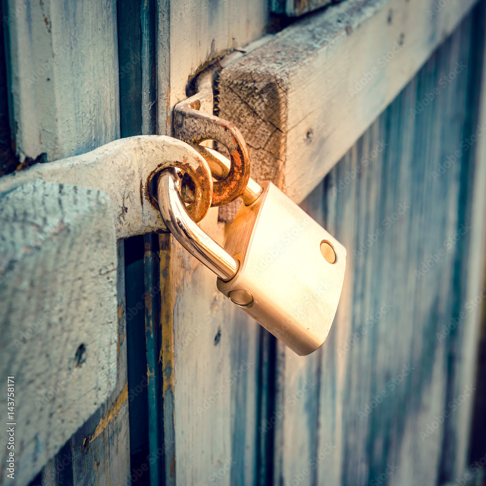 Closed metal padlock on wood door