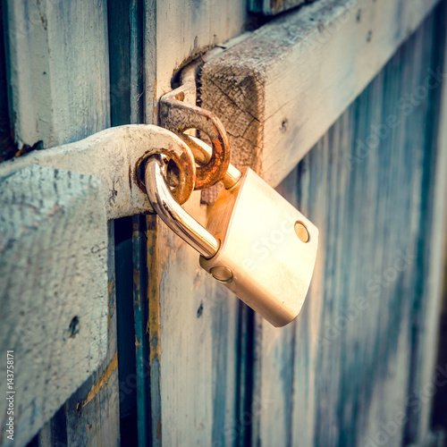 Closed metal padlock on wood door