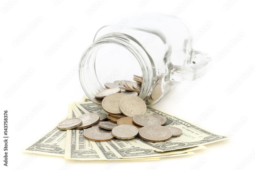 Coins spilling out of a glass jar and isolated on a white background. Coins spilling out of a glass jar and isolated on a white background.
