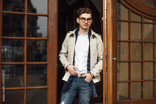 Fashionable man leaving working place, opening doors
