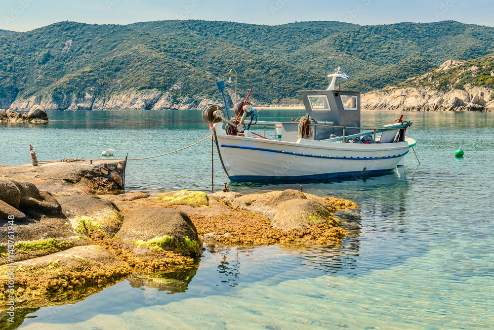 Colorful Greek fishing boat in the natural bay. Typical Greek landscape. Photo from Kalamitsi, Sitonia, Halkidiki, Macedonia, Northern Greece.