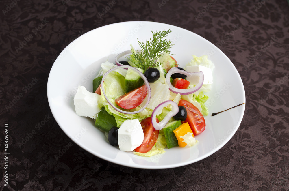 Vegetable salad on a white plate in a restaurant