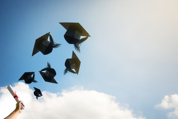 Graduates hands throwing graduation hats.