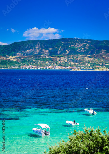 Obraz na płótnie Beach at sunny day with clear blue sky, turquoise sea water and bouts. Photo from Megali Amos or the Big sandy beach, Ammouliani Island, Athos, Halkidiki, Northern Greece. w salonie