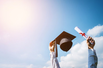 Graduate are celebrating graduation Throwing hands up a certificate and Cap