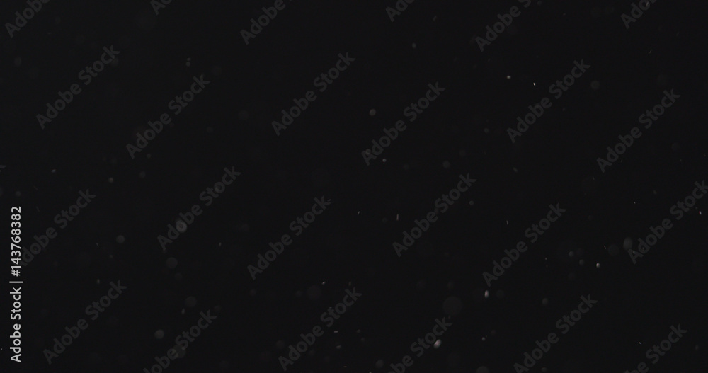 dust particles fly in the air over black background, 4k photo