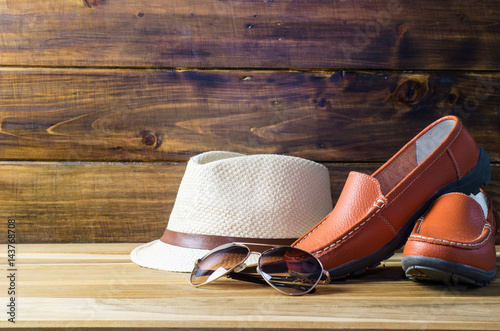 Fototapeta Naklejka Na Ścianę i Meble -  brown shoes sunglasses and hat on wooden floor