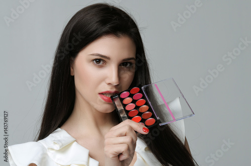 Portrait of a make-up artist who raised the pallet to her mouth