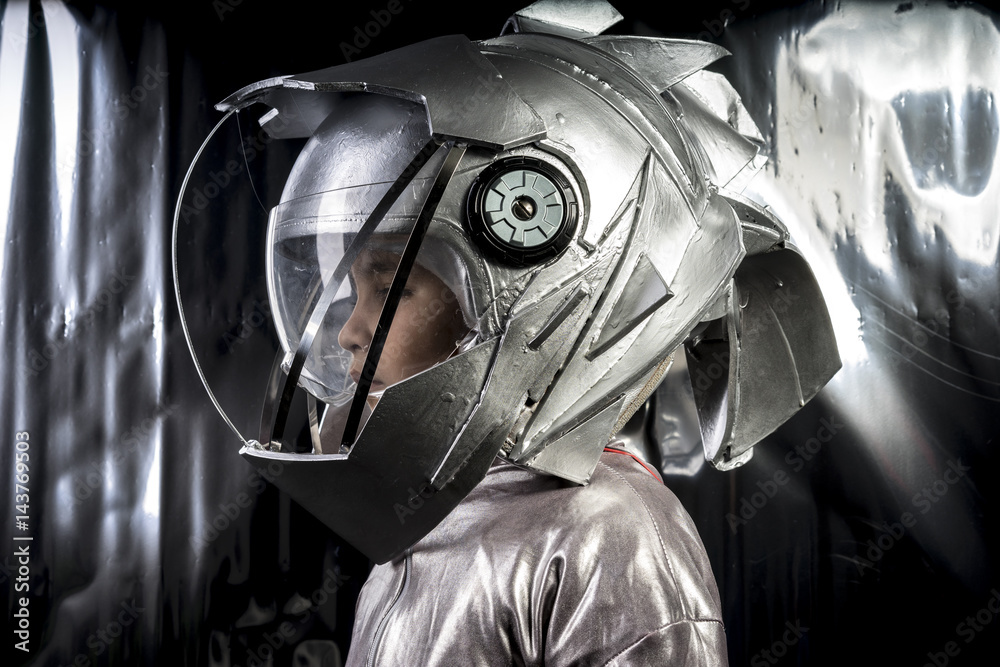 Boy playing to be an astronaut with a space helmet and silver suit on  metallic background Stock Photo | Adobe Stock