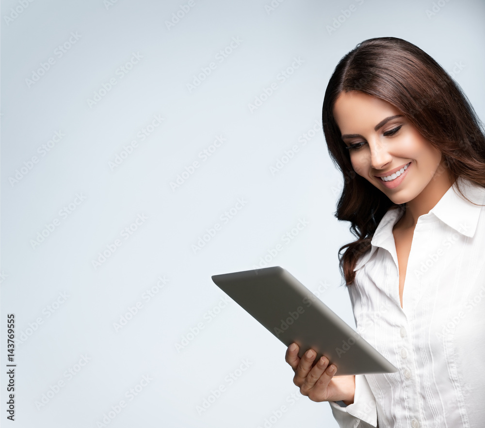 businesswoman using no-name tablet pc, over grey businesswoman using no-name tablet pc, over grey