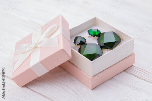 Gold earrings with emerald in the gift box