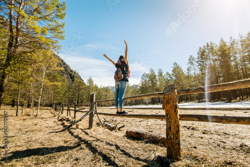 a young girl stands on the fence in the highlands