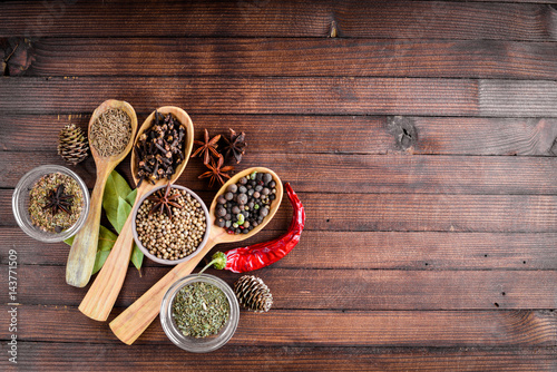A mixture of spices. Wooden spoon. On Wooden background. Top view.