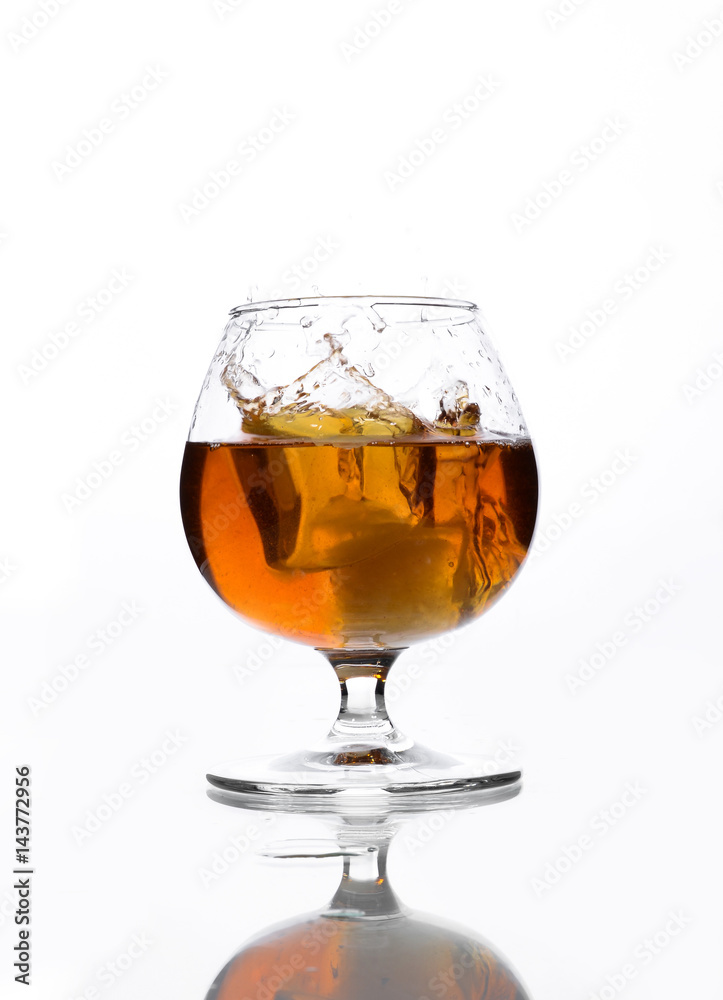 A glass of whiskey in which poured on a white background. A glass of whiskey in which poured on a white background.