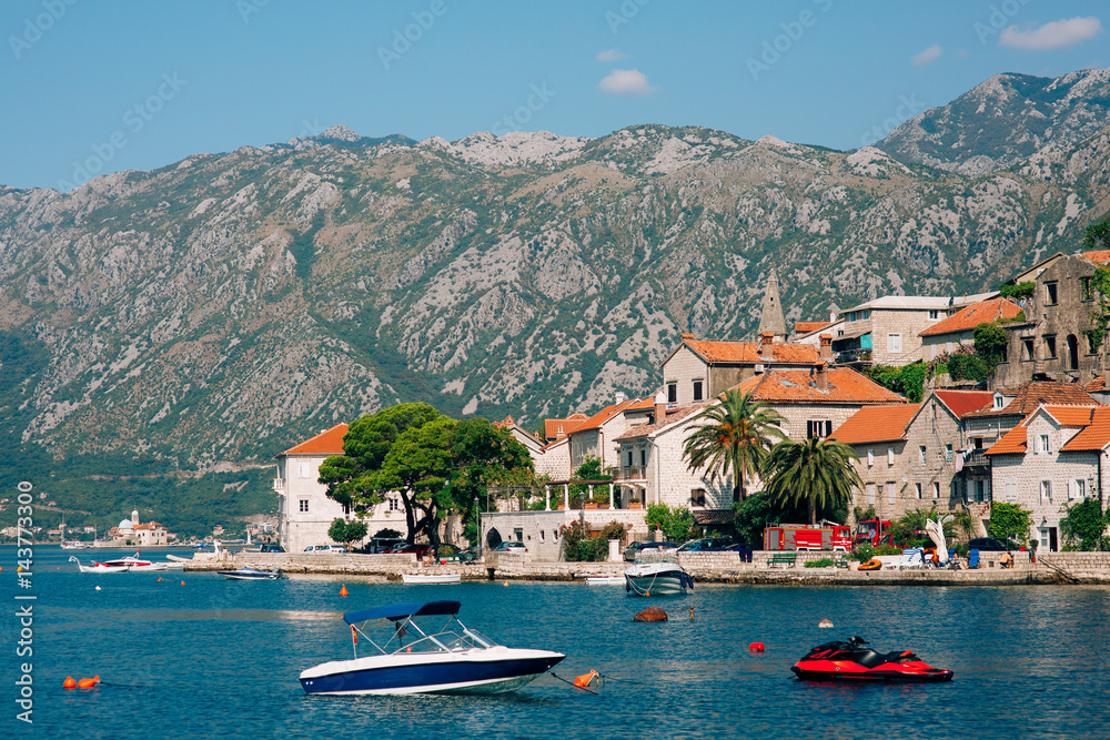 The old town of Perast on the shore of Kotor Bay, Montenegro. The ancient architecture of the Adriatic and the Balkans. Boats and yachts on the dock.