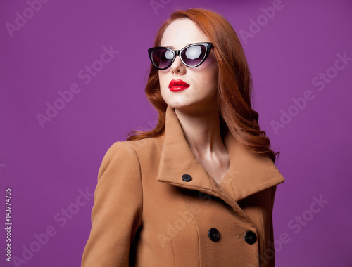 photo of beautiful young woman standing on the wonderful purple studio background