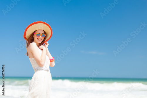 photo of beautiful young woman standing on the wonderful sea background