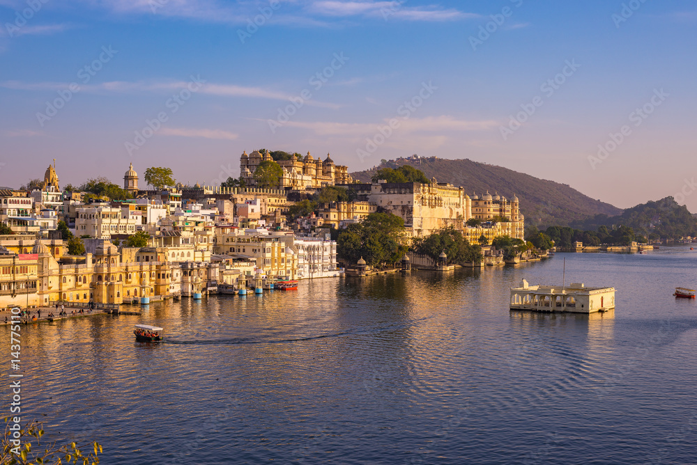 The famous city palace on Lake Pichola reflecting sunset light. Udaipur, travel destination and tourist attraction in Rajasthan, India