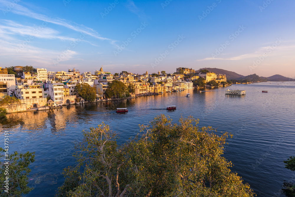 The famous city palace on Lake Pichola reflecting sunset light. Udaipur, travel destination and tourist attraction in Rajasthan, India The famous city palace on Lake Pichola reflecting sunset light. Udaipur, travel destination and tourist attraction in Rajasthan, India