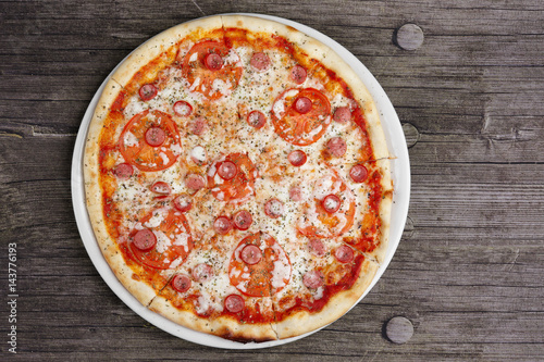 Pepperoni pizza on wooden table, top point of view.