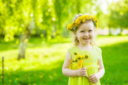 Happy girl with dandelions in summer park