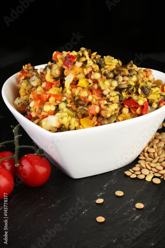 Lentil with carrot and pumpkin ragout in a wooden bowl on a wood