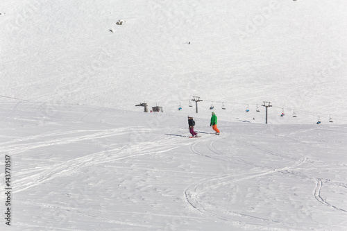 women snowboarder snowboarding on fresh white snow with ski slope on Sunny winter day