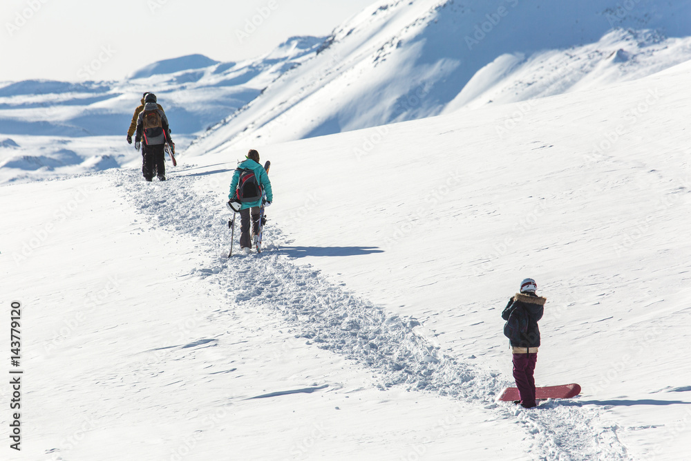 Skiers walk on the frozen trail. Beautiful winter landscape with snow-topped mountains. Ski resort
