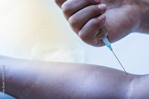 Male drug addict hand  himself an injection.