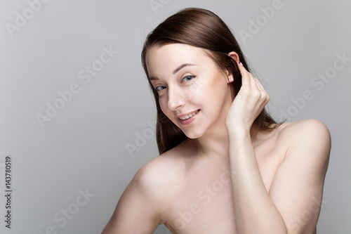 Isolated on gray background studio portrait of young brunette with manicure on nails