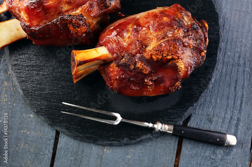Photography Smoked ham hock with herbs and spices on wooden plate.