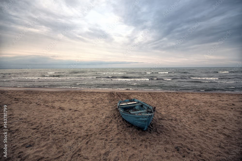 Beautiful landscape of Boat on the beach in cloudy weather. Vintage Boat in the seashore. Azerbaijan Caspian Sea Novkhani Beautiful landscape of Boat on the beach in cloudy weather. Vintage Boat in the seashore. Azerbaijan Caspian Sea Novkhani