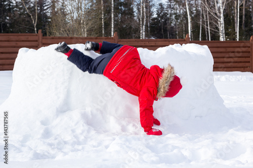 girl climbs the walls of snow fortress